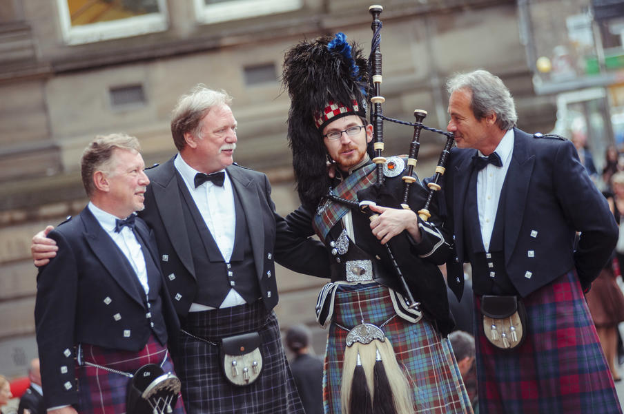 Delegates in hired kilt outfits with a welcome piper.  