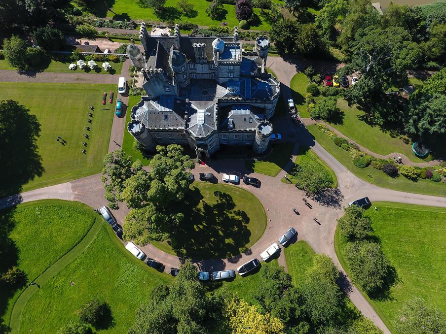 Aerial shot of Classic cars and Segways on a sunny day at Winton Castle