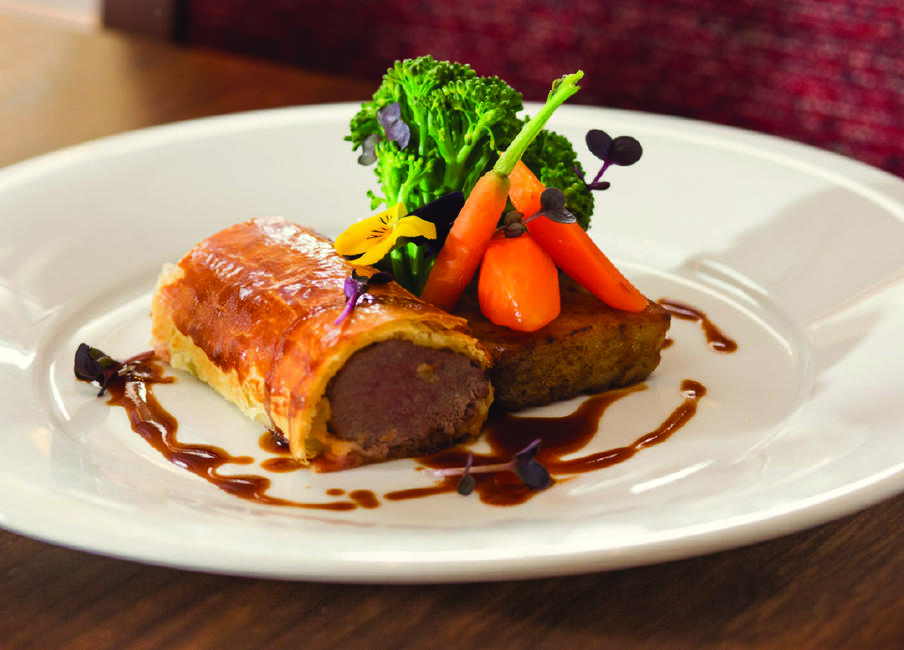 Dinner plate with Scottish borders lamb wellington and a side portion of carrots and broccoli 