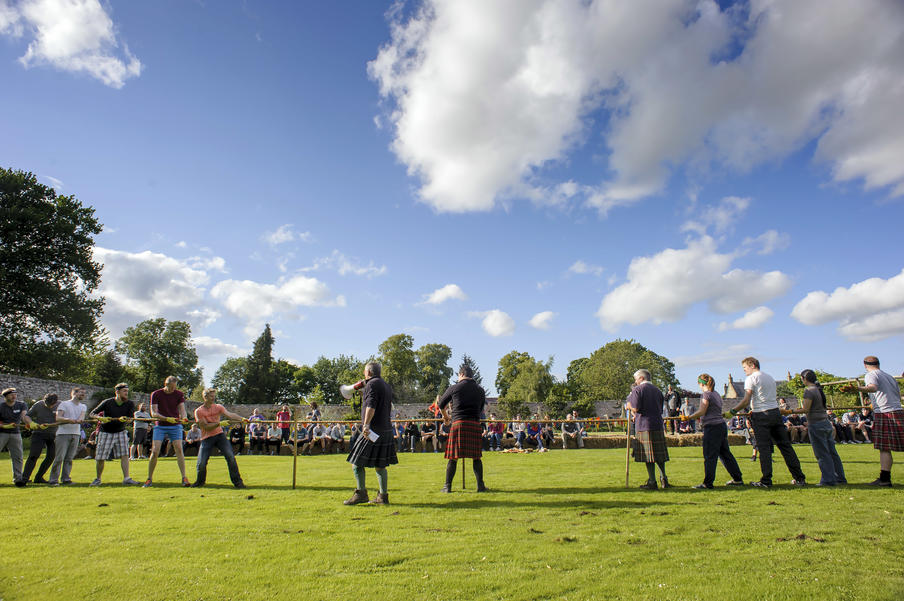 Tug'o'war during highland games in the sunny private walled gardens at Winton Castle