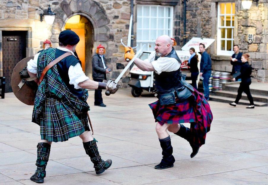 Clan battle with men in traditional Scottish dress