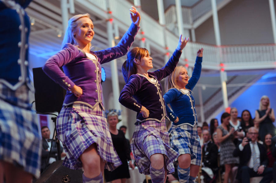 Traditional Highland dancers performing for a corporate crowd at the National Museum of Scotland