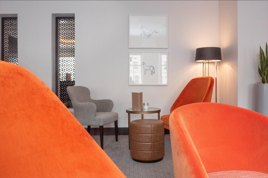 Relaxing Guest Lounge with views of Hill Square, colourful seating and warm lighting in the evening.