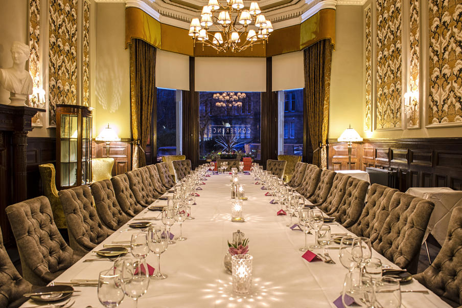 Traditional Georgian Style meeting room with wood paneling and large feature fireplace comfortably seating 14 delegates.