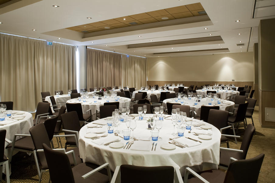 Banqueting room set for dinner on round tables