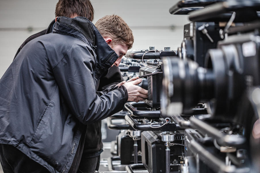 A technician examining a projector in our warehouse.