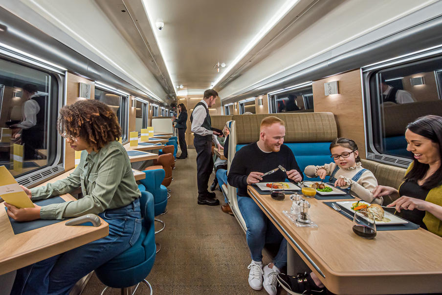 Dining car on board the train with people enjoying food and drink