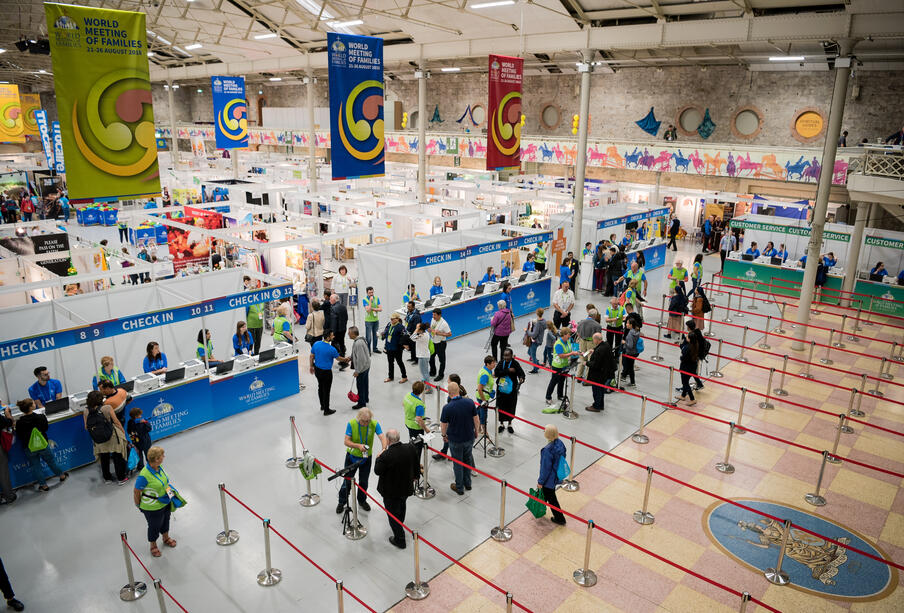 Exhibition floor at a conference with people queuing at check in desks from a birds eye view.