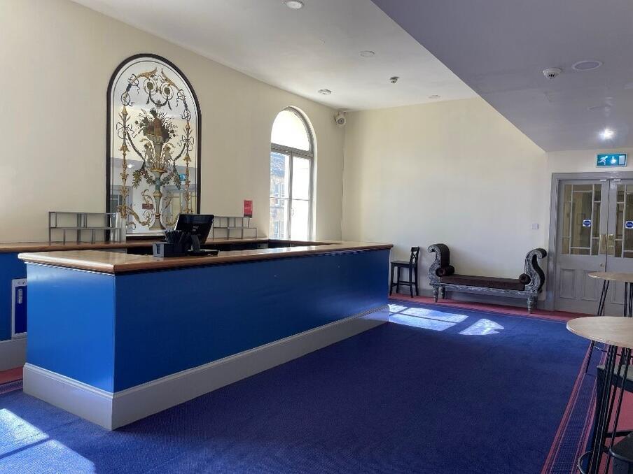 Blue bar and carpet with white walls.